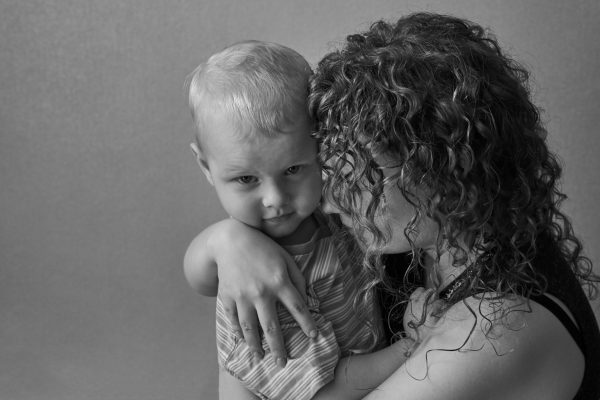 Frightened mother hugs her little son, the theme of domestic violence, black and white photo.