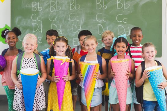 Happy kids holding gifts in classroom Happy kids holding gifts in classroom